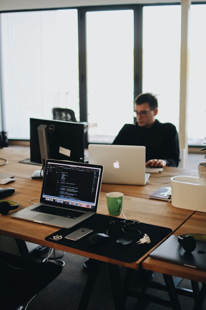 Mastering the First Impression: Your intriguing post title goes here A web developer working on code in a modern office setting with multiple devices.