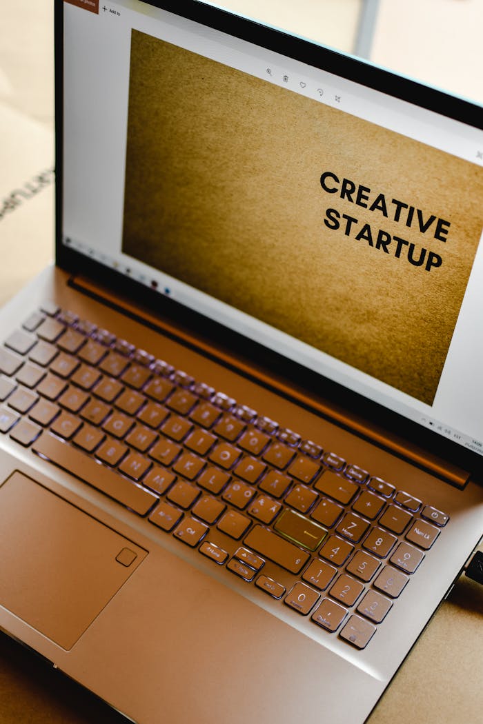 The Art of Drawing Readers In: Your attractive post title goes here Laptop displaying 'Creative Startup' concept in an inspiring workspace.